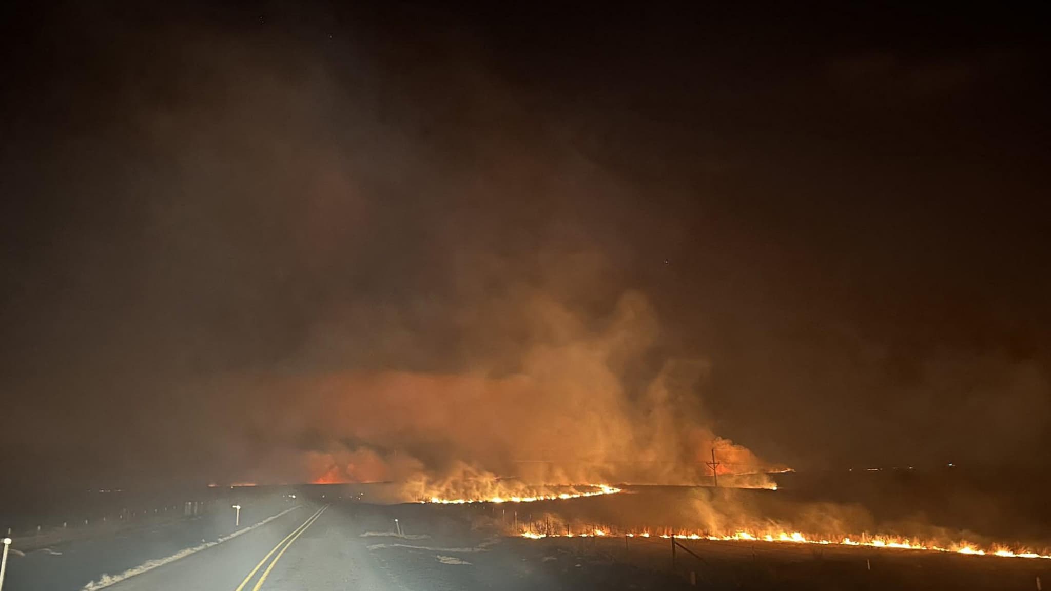 Le feu traverse une route dans l'incendie de Smokehouse Creek dans la soirée du 27 février 2024 dans le Texas panhandle.