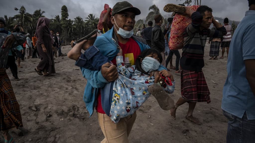 Des habitants d'un village de Lumajang en Indonésie prennent la fuite après l'éruption du volcan Semeru, le 4 décembre 2021.