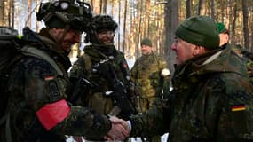 Le ministre allemand de la Défense Boris Pistorius (à droite) serre la main d'un soldat des forces armées allemandes lors d'un exercice du contingent allemand de l'OTAN, le 7 mars 2023 à Pabradė, en Lituanie.