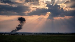 Au loin, près de Zhdanivka à 40 kilomètres de Donetsk, la carcasse fumante d'un chasseur ukrainien abattu, le 7 août 2014.