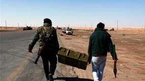 Combattants rebelles transportant des munitions sur le front à l'entrée ouest d'Ajdabiah. Paris et Londres, à l'avant-garde de l'intervention militaire dans le ciel libyen, ont pressé mardi l'Otan d'intensifier ses raids pour détruire les armes lourdes dé