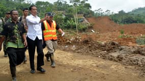 Le président indonésien Joko Widodo (le deuxième à gauche sur la photo) constate les dégâts du glissement de terrain dans le village de Jemblung, sur l'île de Java, en Indonésie, le 14 décembre 2014. 