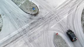 Une voiture circule à une intersection de Saint-Pierre-de-Plesguen (Ille-et-Vilaine), lors d'une journée enneigée, le 9 janvier 2024.