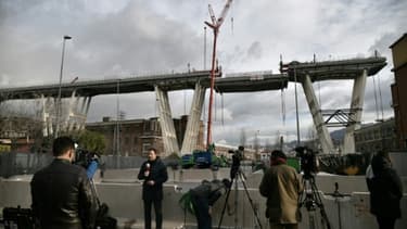 Les médias observent l'amorce de la descente d'un tronçon du pont Morandi dans le cadre de son démantèlement, à Gênes (Italie) le 9 février 2019