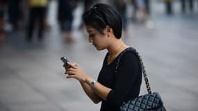Une femme utilise son téléphone dans la rue à Shanghai.