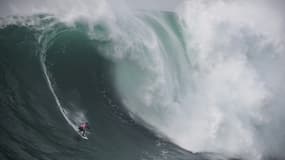Le Français Eric Rebière lors d'une compétition de surf de grosses vagues, le 10 février 2022 à Nazaré au Portugal