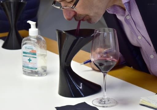 Un courtier utilise le crachoir après avoir gouté un vin lors d'une dégustation dans le laboratoire de l'œnologue Eric Boissenot à Lamarque près de Bordeaux, le 4 juin 2020 Un courtier utilise le crachoir après avoir gouté un vin lors d'une dégustation dans le laboratoire de l'œnologue Eric Boissenot à Lamarque près de Bordeaux, le 4 juin 2020