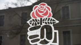 Autocollant représentant le poing et la rose, emblèmes du Parti socialiste, sur la façade vitrée du bureau du PS à Gers le 2 janvier 2024.