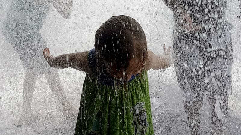 Une petite fille tente de se rafraîchir à Pantin, en juin 2017.