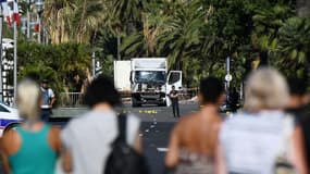 Des policiers devant le camion qui a foncé sur le foule rassemblée le soir du 14 juillet sur la promenade des Anglais, au lendemain de l'attentat, le 15 juillet 2016 à Nice