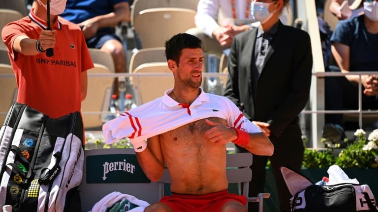 Novak Djokovic se change pendant une pause en finale du tournoi de Roland-Garros contre Stefanos Tsitsipas, le 13 juin 2021