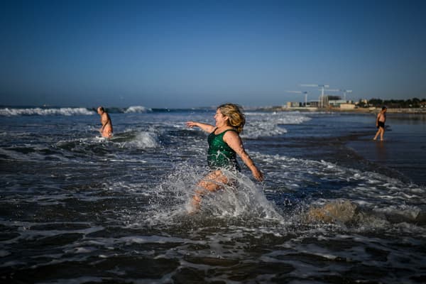 Des personnes posent pour une photo avant de prendre leur premier bain de mer de l'année lors des célébrations du Nouvel An sur la plage de Carcavelos à Oeiras, dans la banlieue de Lisbonne, le 1er janvier 2024.