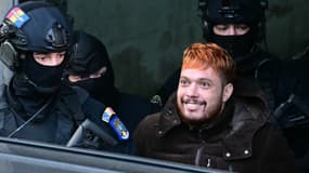 Mohamed Amra  est escorté par des policiers hors de la Cour d'appel de Bucarest le 23 février 2025 après son arrestation la veille.