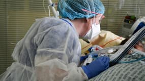 Un membre du personnel soignant et un patient atteint du Covid-19, dans l'unité de soins intensifs de l'hôpital Ambroise-Paré, à Boulogne-Billancourt, près de Paris, le 8 mars 2021. (Photo d'illustration)