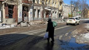Une femme traverse une rue de Kharkiv, dans l'est de l'Ukraine, le 12 mars 2022