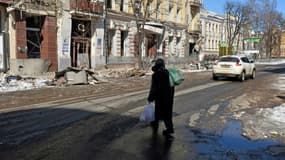 Une femme traverse une rue de Kharkiv, dans l'est de l'Ukraine, le 12 mars 2022