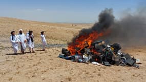 Des talibans surveillent le bûcher d'instruments de musique enflammé dans la province de Herat en Afghanistan, le 29 juillet 2023.