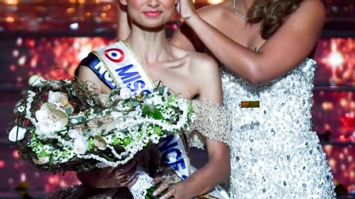 Miss Nord-Pas-de-Calais, Eve Gilles (L), est couronnée Miss France 2024 par Miss France 2023 Indira Ampiot (D), à Dijon, le 16 décembre 2023