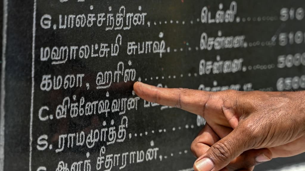 Une personne montre le nom de Kamala Harris sur le mur du temple de Thulasendrapuram, en Inde, indiquant les dons effectués pour l'édifice, le 23 juillet 2024