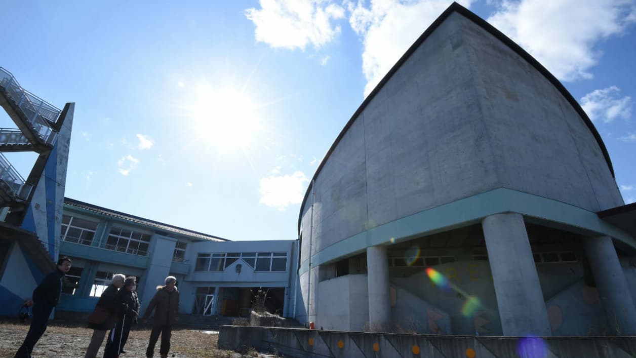 Des touristes devant une école primaire fermée à Namie, le 11 février 2016, cinq ans après le tremblement de terre ayant provoqué l'explosion de la centrale nucléaire. Des touristes devant une école primaire fermée à Namie, le 11 février 2016, cinq ans après le tremblement de terre ayant provoqué l'explosion de la centrale nucléaire.