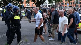 Un manifestant tenant un morceau de béton se dirige vers la police anti-émeute alors que des affrontements éclatent à Bristol le 3 août 2024 lors de la manifestation "Enough is Enough".