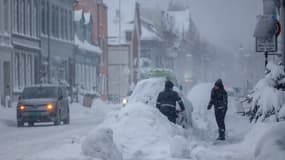Des personnes retirent de la neige d'une voiture à Kristiansand, en Norvège, le 2 janvier 2024