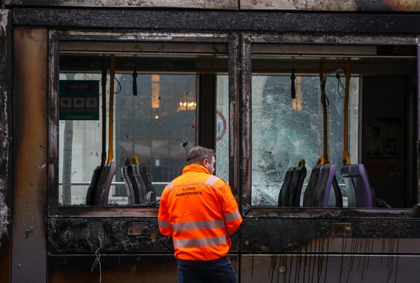 Un ouvrier évalue les dégâts d'un tramway endommagé par le feu à Dublin, le 24 novembre 2023, à la suite d'une nuit de manifestations.