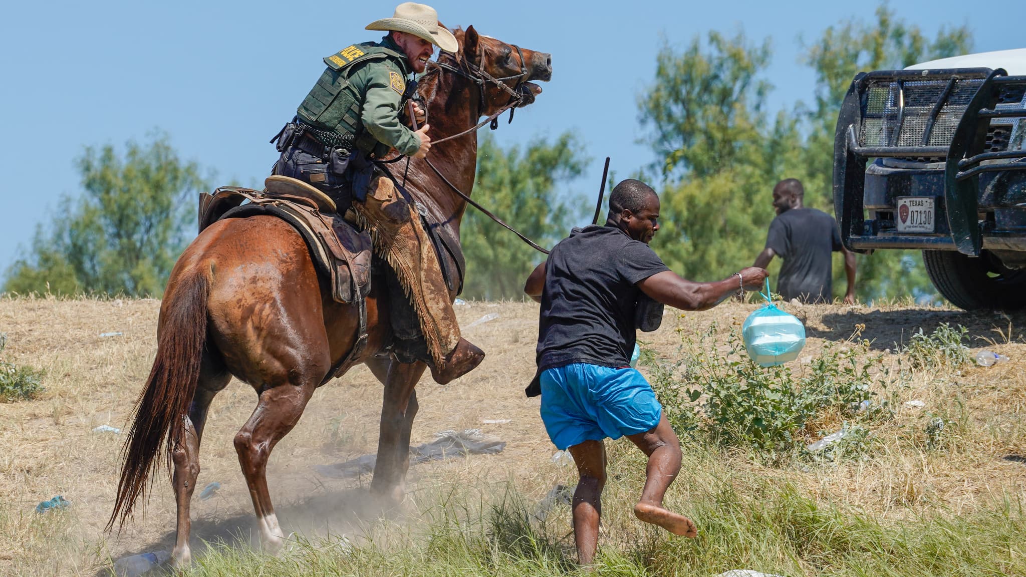 Un agent de la police des frontières américain à cheval essayant d'empêcher un homme de rejoindre le camp actuel près du fleuve Rio Grande, le 19 septembre 2021 Un agent de la police des frontières américain à cheval essayant d'empêcher un homme de rejoindre le camp actuel près du fleuve Rio Grande, le 19 septembre 2021