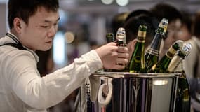 Un Chinois au salon du vin de Hong Kong, en mai 2014, regardant des bouteilles de Champagne.
