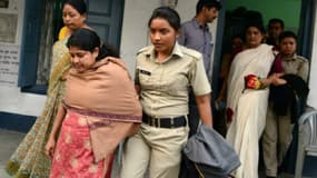 La police indienne escorte Chandana Chakraborty (D) et Sonali Mondal (G), dans l'enquête sur un trafic d'enfants, à Jalpaiguri le 21 février 2017