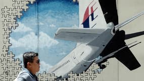 Un homme passe devant une fresque représentant l'appareil de Malaysia Airlines le 8 mars 2016 en Malaisie. 
