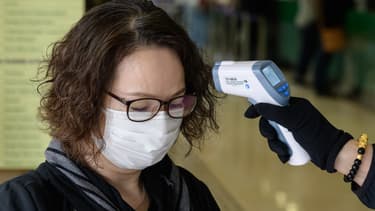 Une femme se fait prendre sa température à Hong-Kong, le 17 mars 2020. (PHOTO D'ILLUSTRATION)