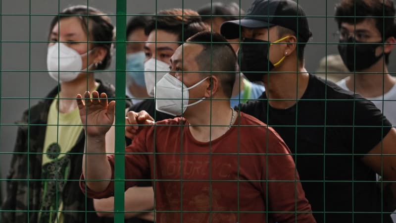 Les habitants du quartier de Xuhui à Shanghai, le 6 juin 2022, derrière un grillage. 