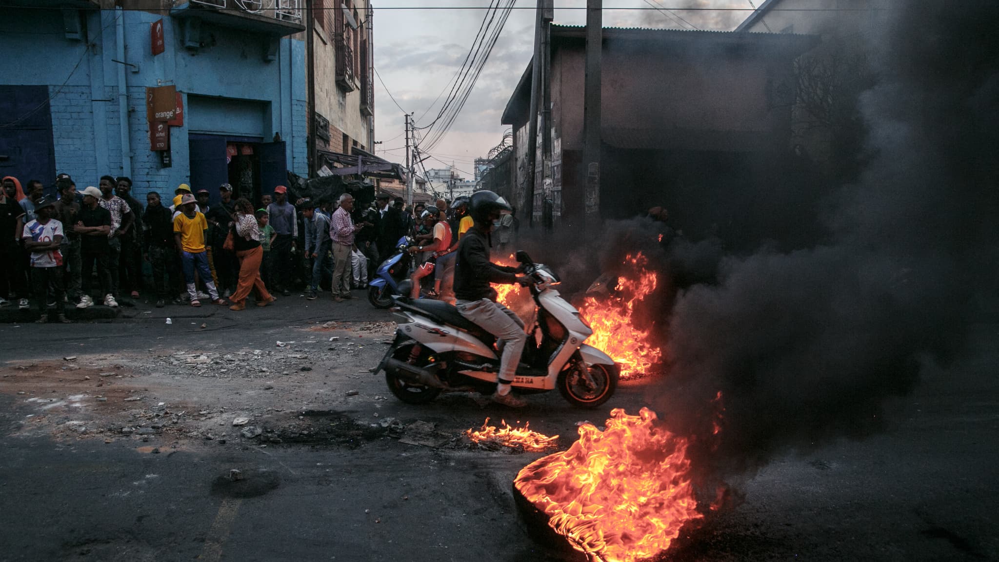 Un motocycliste passe devant des barricades érigées par des manifestants qui protestent contre les coupures répétées d'eau et d'électricité à Antananarivo, le 25 septembre 2025. 