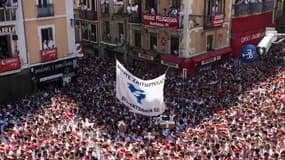 Des participants à la San Fermin brandissent une banderole aux prisonniers basques au coup d'envoi des festivités, le 6 juillet 2019 à Pampelune en Espagne. 