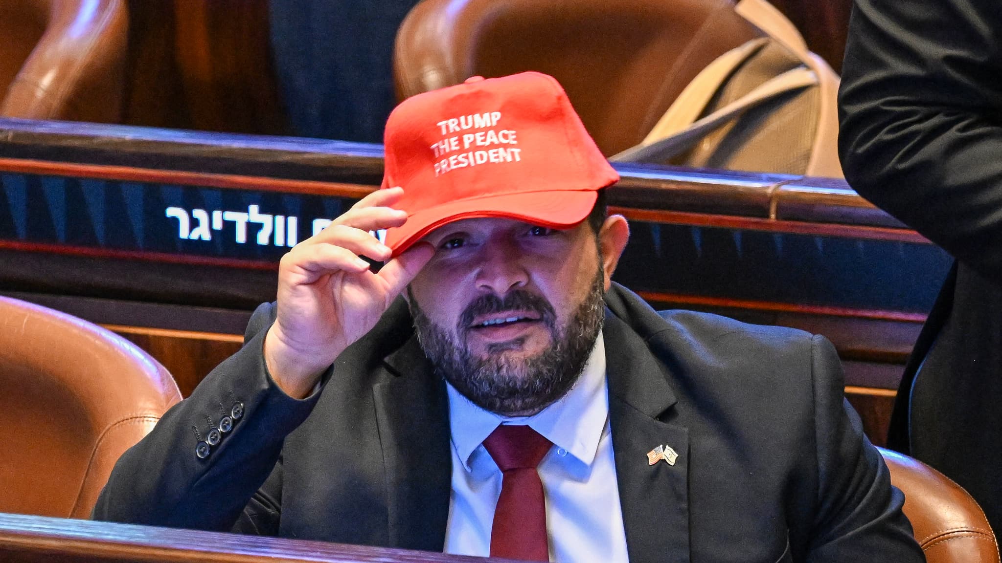 Un homme tenant une casquette "Trump the peace president" à la Knesset, le parlement israélien le 13 octobre 2025
