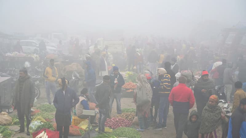 Des vendeurs vendent des légumes sur un marché dans un contexte de smog intense dans la banlieue d'Amritsar (Pakistan), le 14 décembre 2023.