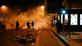 Des supporteurs du PSG shootent dans des gaz lacrymogènes sur les Champs-Elysées, le 23 août 2020 à Paris, après la finale de la Ligue des champions perdue par le PSG face au Bayern de Munich