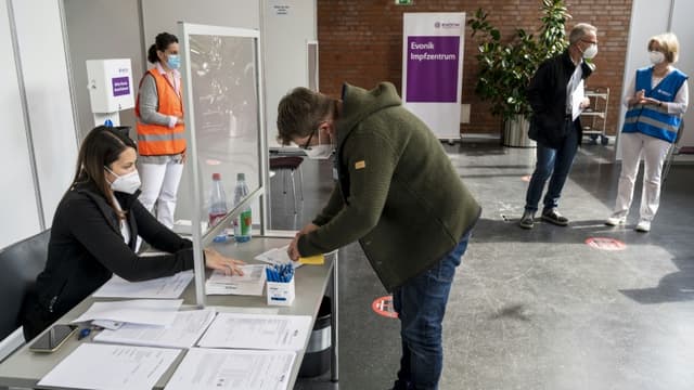 Un employé du groupe de chimie Evonik remplit un formulaire pour se faire vacciner contre le Covid-19 sur son lieu de travail, le 19 mai 2021 à Hanau, en Allemagne