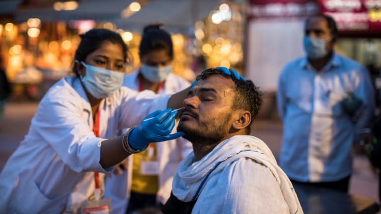 Dépistage du Covid-19 sur des pèlerins au bord du Gange lors du rassemblement de Kumbh Mela à Haridwar, le 12 avril 2021 en Inde