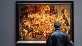 Un homme regarde le tableau "La bataille entre Carnaval et Carême" du peintre néerlandais Pieter Brueghel le Jeune avant une mise aux enchères à Londres, en 2011.