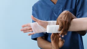 Un médecin bande la main d'un patient (photo d'illustration). 