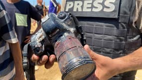 Un journaliste tient l'appareil photo couvert de sang appartenant à la photojournaliste palestinienne Mariam Dagga, journaliste indépendante pour l'AP tuée lors d'une frappe israélienne sur l'hôpital Nasser à Khan Yunis, dans le sud de la bande de Gaza, lors de ses funérailles le 25 août 2025.
