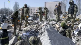 Des opérations de secours se poursuivaient, samedi 19 mars 2022, à Mykolaïv, après que des tirs de roquettes ont dévasté une caserne militaire.