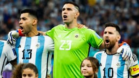Emiliano Martinez au milieu de Cristian Romero et Lionel Messi, à Doha le 13 décembre 2022