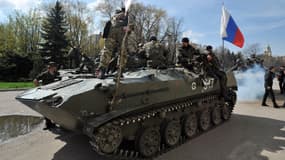 Des hommes armés sur un blindé arborant un drapeau russe à Slavyansk
