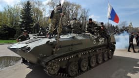 Des hommes armés sur un blindé arborant un drapeau russe à Slavyansk