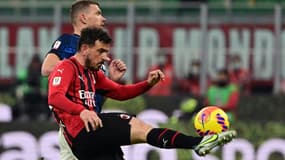 Le milieu de terrain de l'AC Milan, Alessandro Florenzi, dégage le ballon devant l'attaquant bosnien de l'Inter Milan, Edin Dzeko, lors de la demi-finale aller de la Coupe d'Italie, le 1er mars 2022 au Stade Giuseppe Meazza