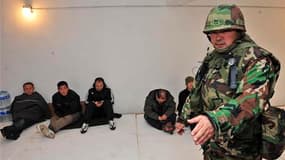Habitants de l'île de Yeonpyeong dans un abri antiaérien, sous le contrôle d'un soldat sud-coréen. L'armée sud-coréenne a entamé ses exercices d'artillerie à munitions réelles sur cette île proche de la ligne de démarcation avec la Corée du Nord, où des t