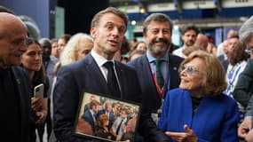 
Le président français Emmanuel Macron (au centre) tient une photo alors qu'il visite le centre d'exposition "La Baleine" un jour avant l'ouverture de la troisième Conférence des Nations Unies sur les océans (UNOC)